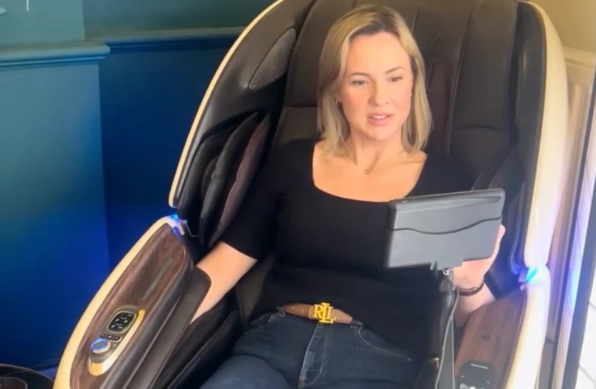 A guest choosing a programme on the AI massage chair at Floatwell Cambridge
