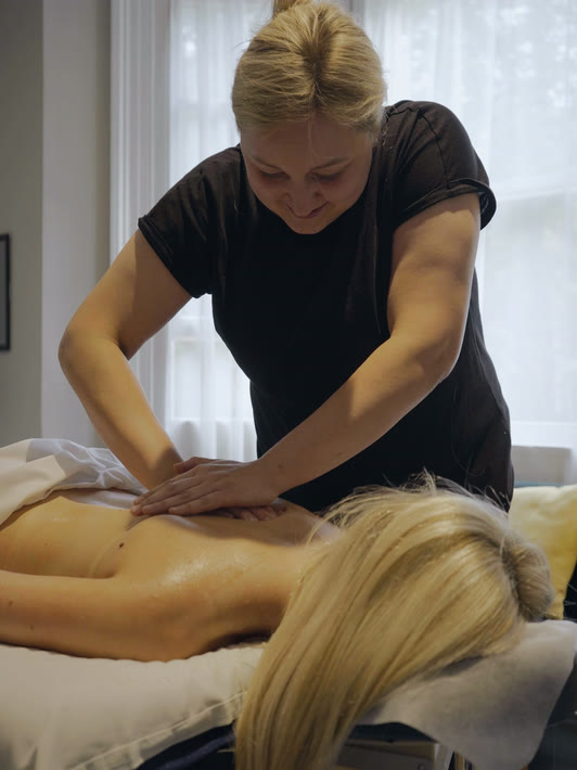 A therapist working into a guest's shoulders during a massage at Floatwell Cambridge