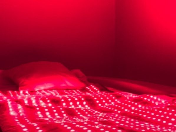 The red light therapy bed lit up in a private room