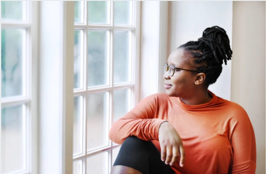 A guest sitting quietly by a window, looking out