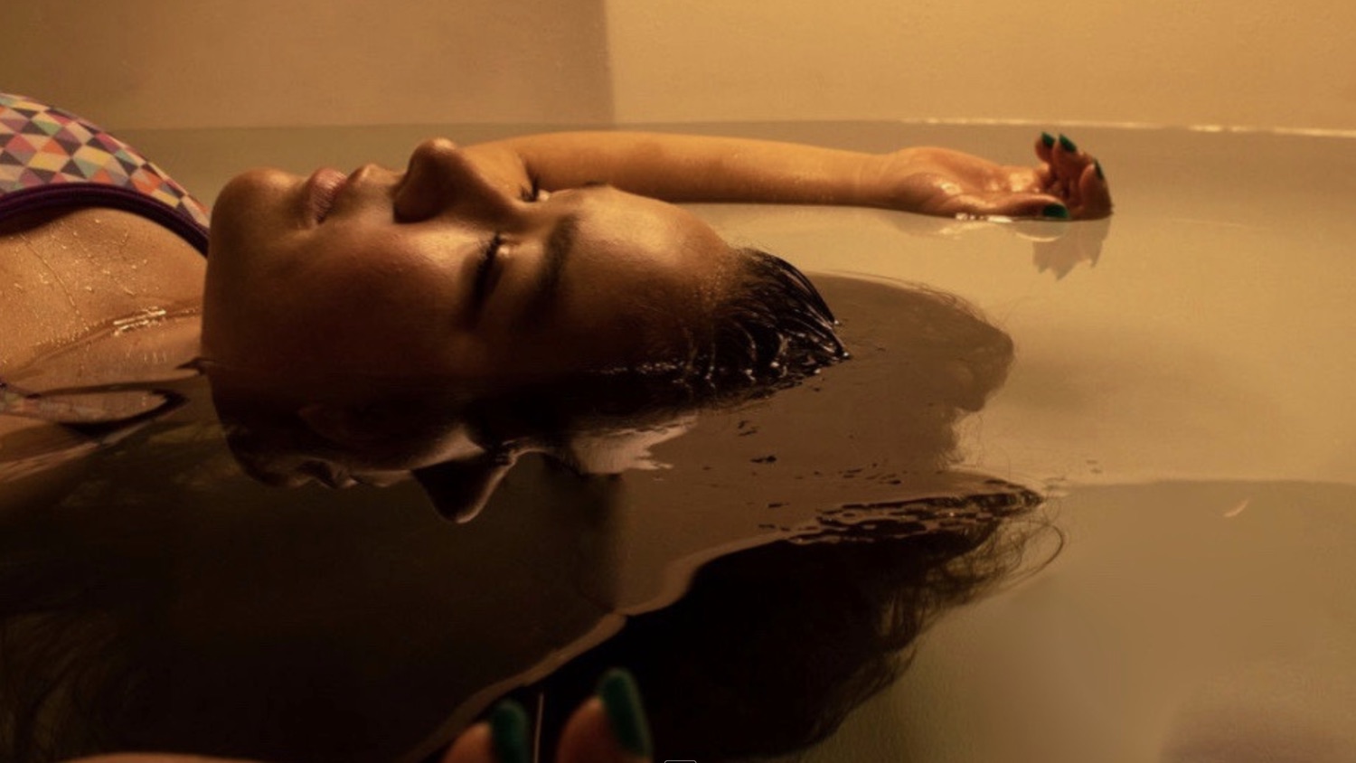 A floater resting with eyes closed in warm, amber-lit water