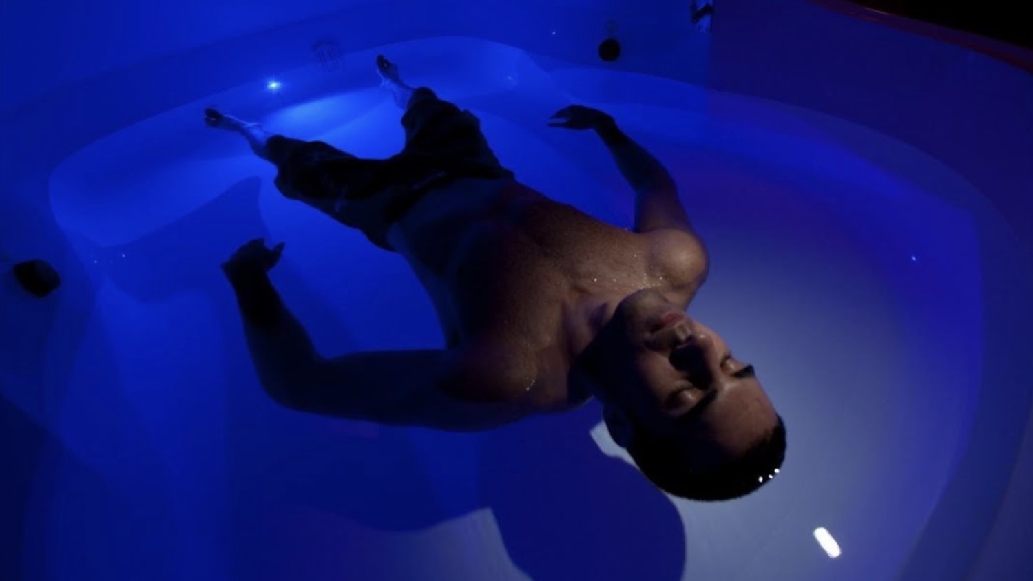 A single floater resting in a private, blue-lit float pod