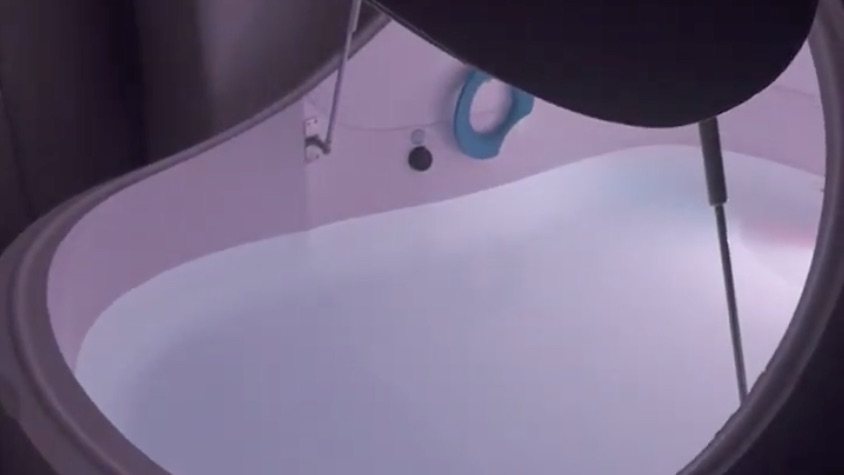 An empty float pod with the lid raised, the water still and clear