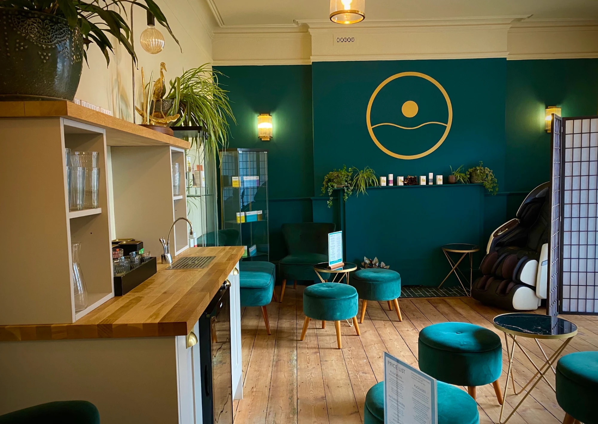 The lounge at Floatwell Cambridge — velvet stools, the price list and the AI massage chair
