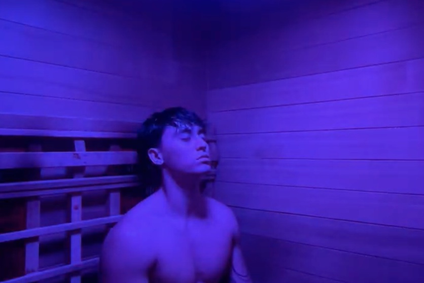 A guest in the infrared sauna at Floatwell Cambridge, lit with chromotherapy
