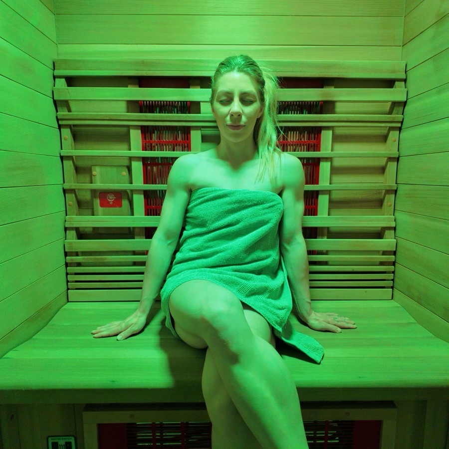A guest in the full-spectrum infrared sauna at Floatwell Cambridge, lit with chromotherapy