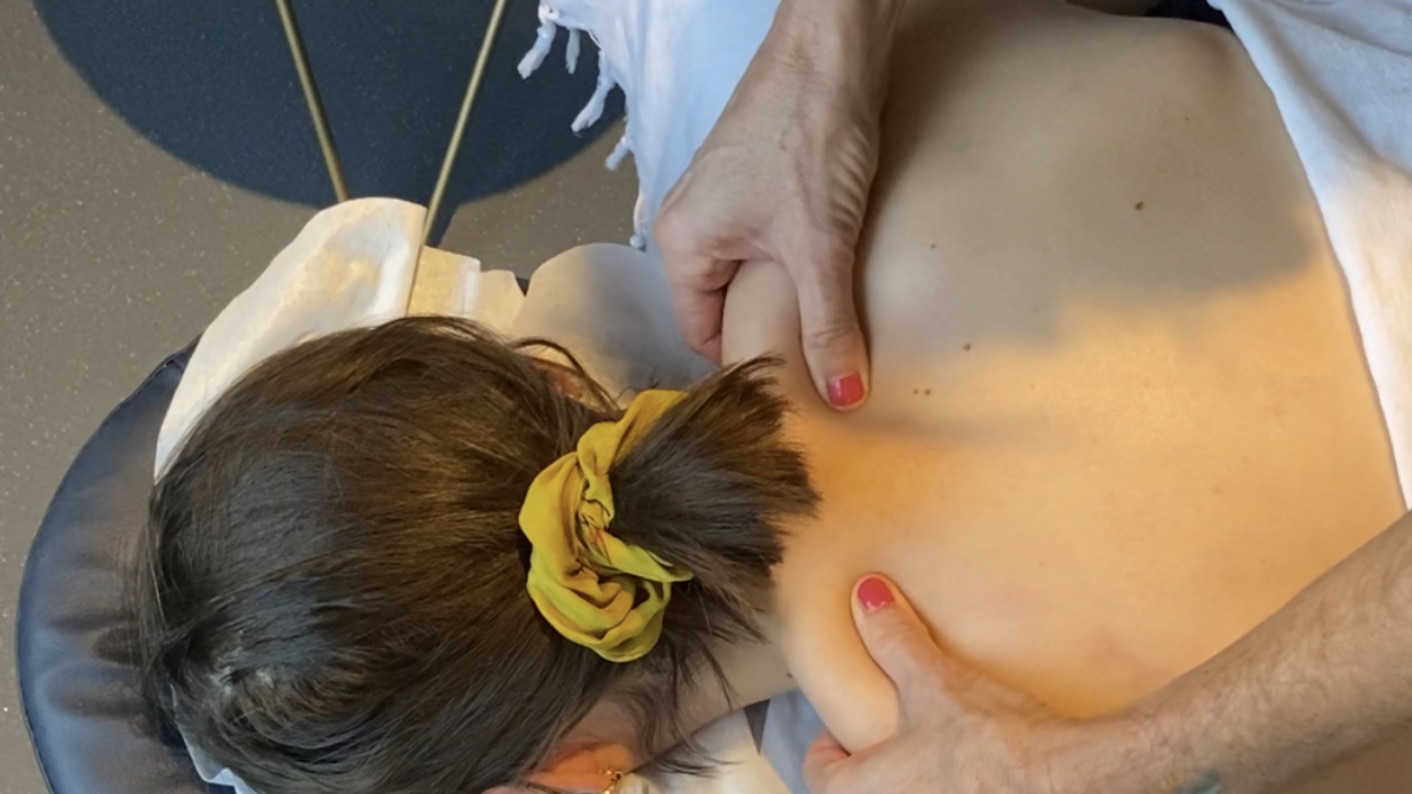 A therapist releasing tension in a client's neck and shoulders