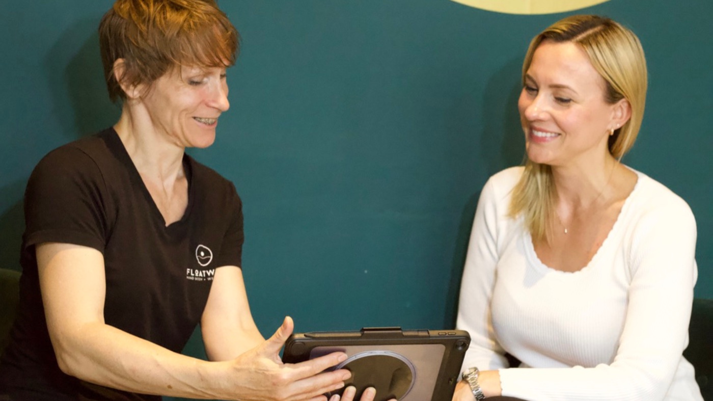 A Floatwell therapist talking a client through the packages on a tablet