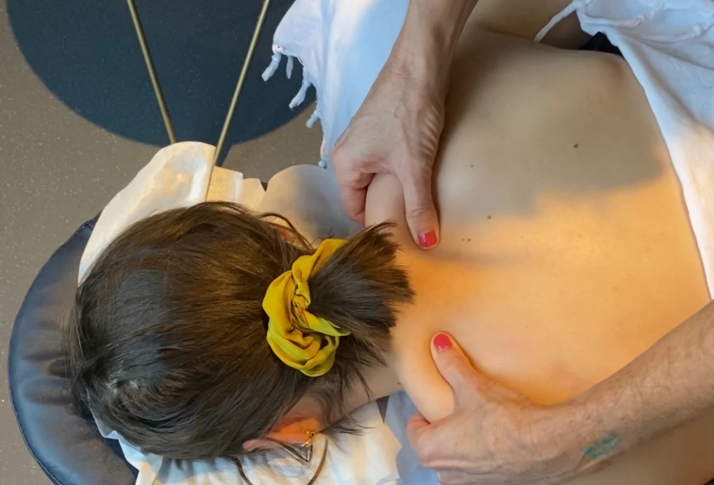 A massage therapist easing tension across a client's shoulders and upper back at Floatwell