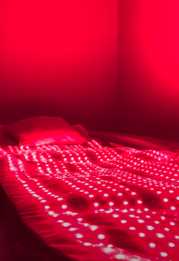 The red-light therapy bed at Floatwell Cambridge, its LED mat lit