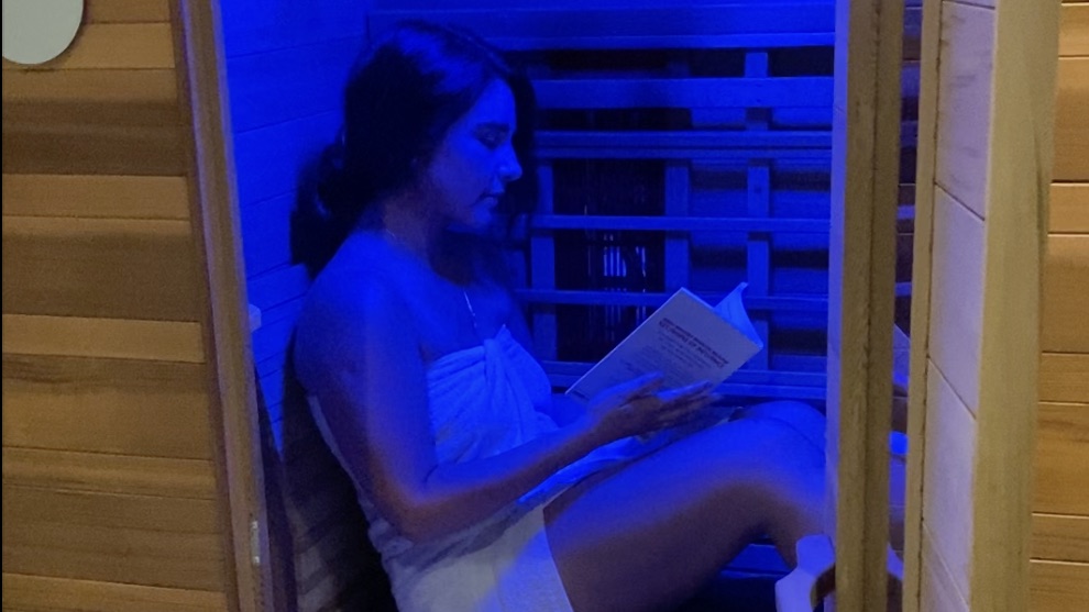 A guest reading a book in the infrared sauna