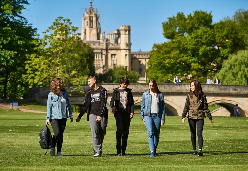 A group of students walking together across the college backs in Cambridge