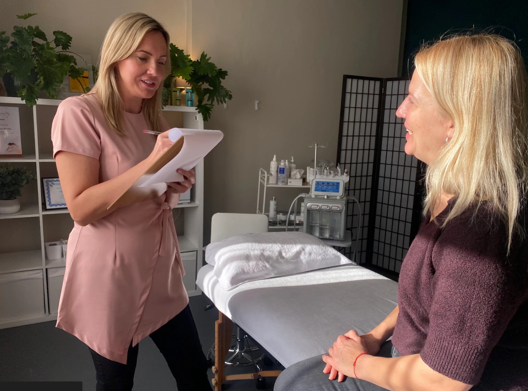 A practitioner taking a client through her consultation notes in a treatment room at Floatwell
