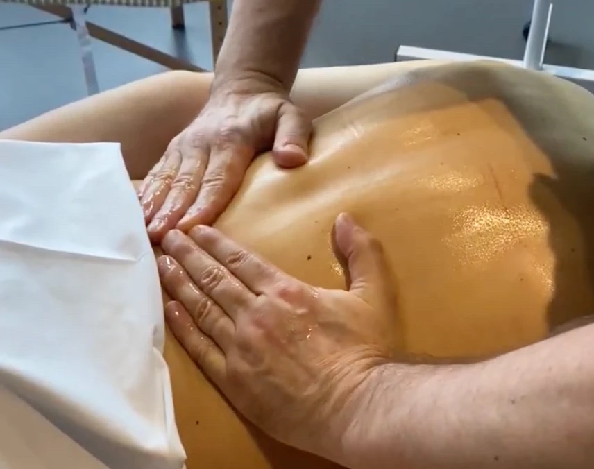 A therapist working across a client's back during a massage at Floatwell Cambridge